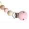 This pacifier holder is made of wooden beads. Some beads have a raw wood finish and some are painted pink or light neutral colours such as grey or beige. The technique of painting ensures absolute safety for your baby. A stunning yet practical product.