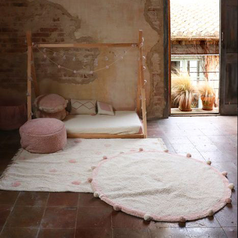 Complete your room with this natural pink round shaped soft cotton rug with a cute touch of pom poms from Lorena Canals. 