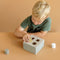 The wooden shape sorter is a creative sorting game for children. They learn to recognize and match shapes and colours, while fine-tuning their hand-eye coordination. The box is illustrated with Little Goose and his friends at the farmer’s pond and made of sturdy wood. Little hands will easily grasp the shapes to push them into the correct opening. This classic toy is educational and fun at the same time! 